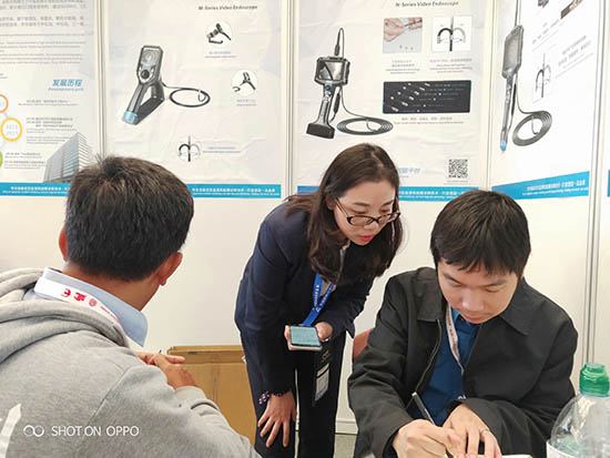 亞泰光電展臺前，公司內窺鏡工程師與客戶親密交談為
